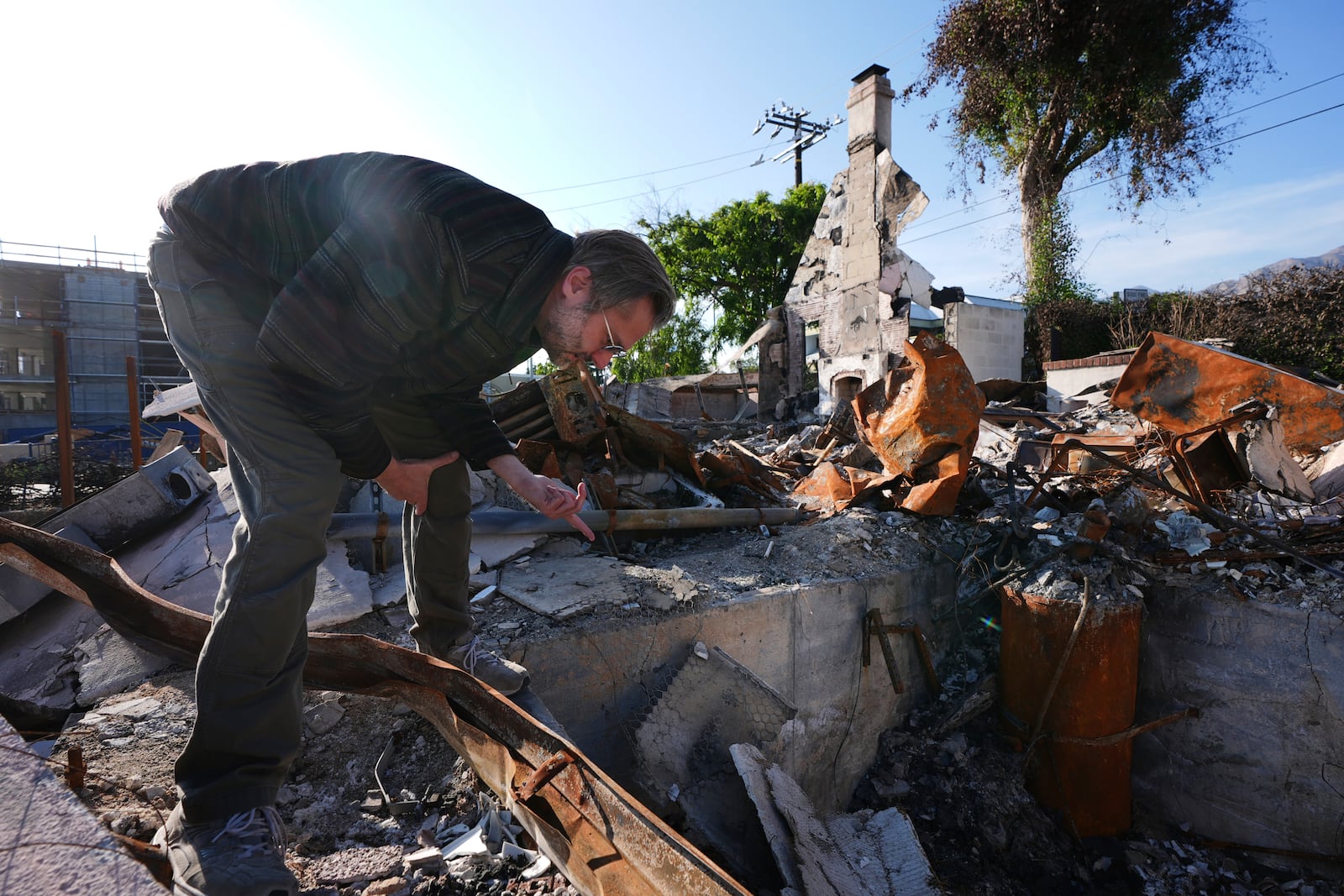 Tim Vordtriede looks through the remains of his property, which was destroyed by the Eaton Fire in Altadena, Calif., on Tuesday, April 22, 2025. (AP Photo/Damian Dovarganes)