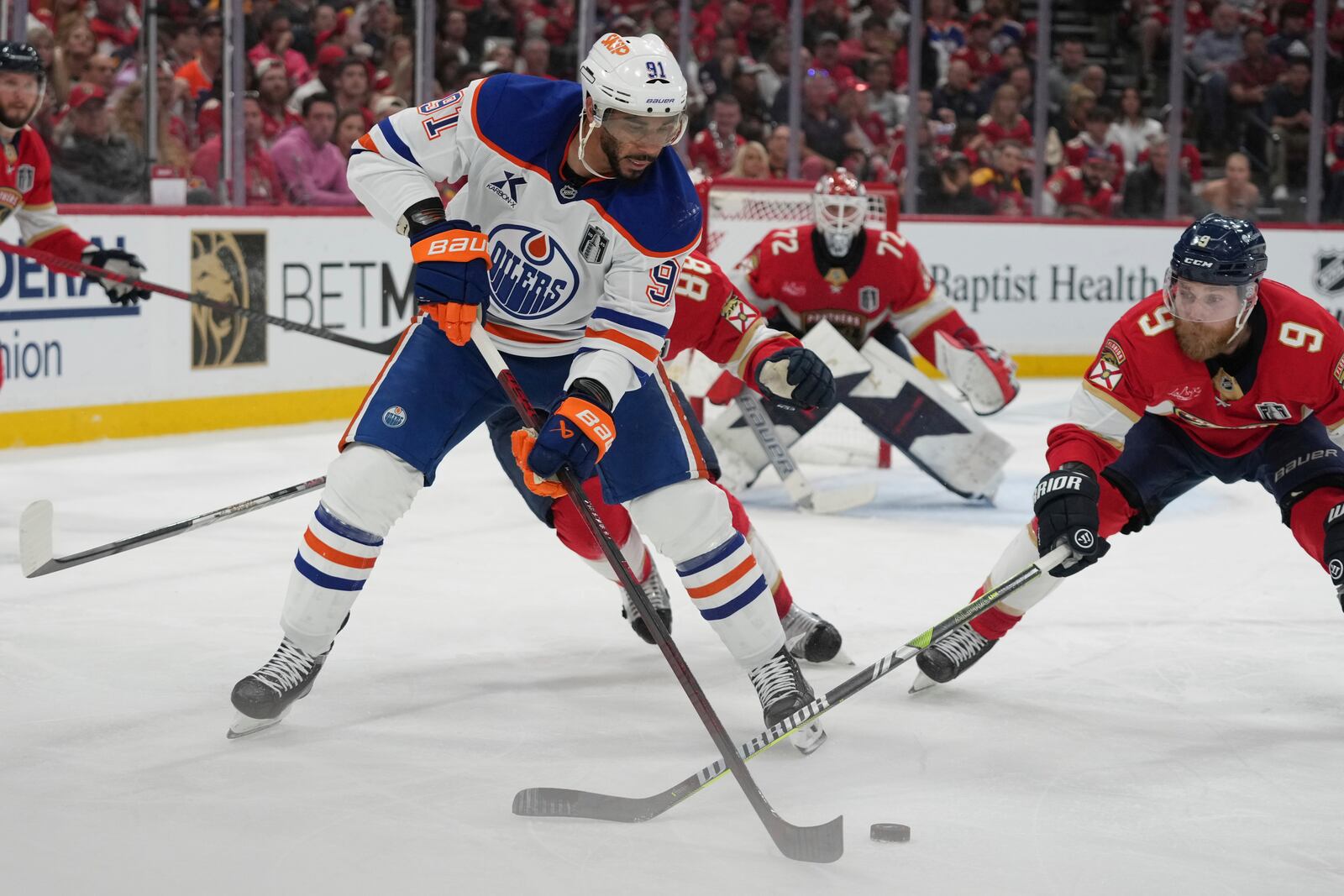 Edmonton Oilers left wing Evander Kane (91) and Florida Panthers center Sam Bennett (9) go after the puck during the third period of Game 4 of the NHL hockey Stanley Cup Final Thursday, June 12, 2025, in Sunrise, Fla. (AP Photo/Lynne Sladky)