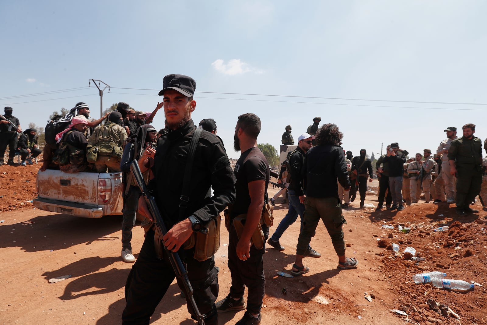 Syrian government security forces block Bedouin fighters, background, from entering Sweida province, in Busra al-Harir village, southern Syria, Sunday, July 20, 2025. (AP Photo/Omar Sanadiki)