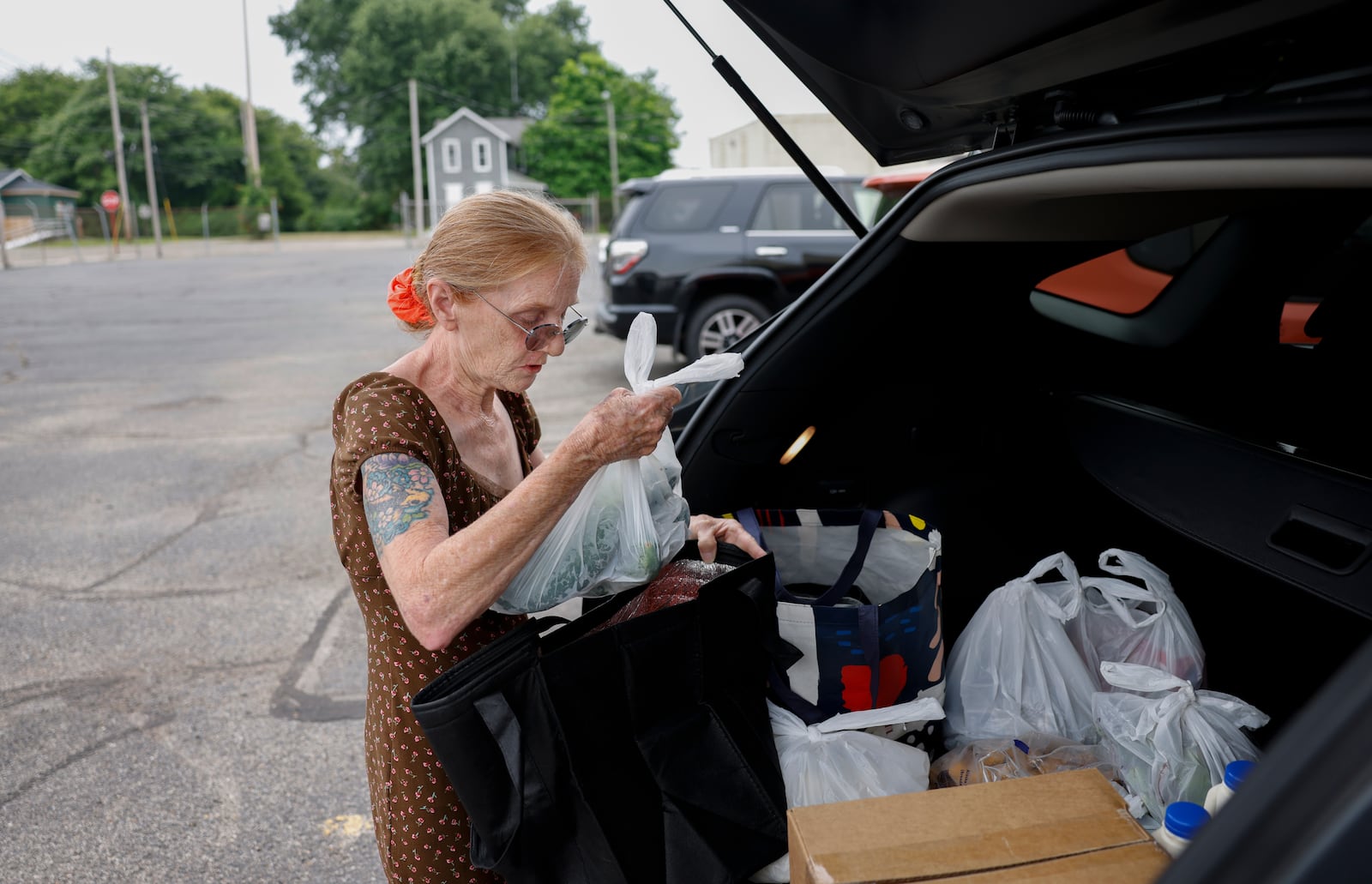 Patricia Clark, of Springfield, organizes a bag of cucumbers she got from OrderAhead, Second Harvest Food Bank's choice program, on Wednesday, July 9, 2025, at Second Harvest Food Bank. JOSEPH COOKE/STAFF