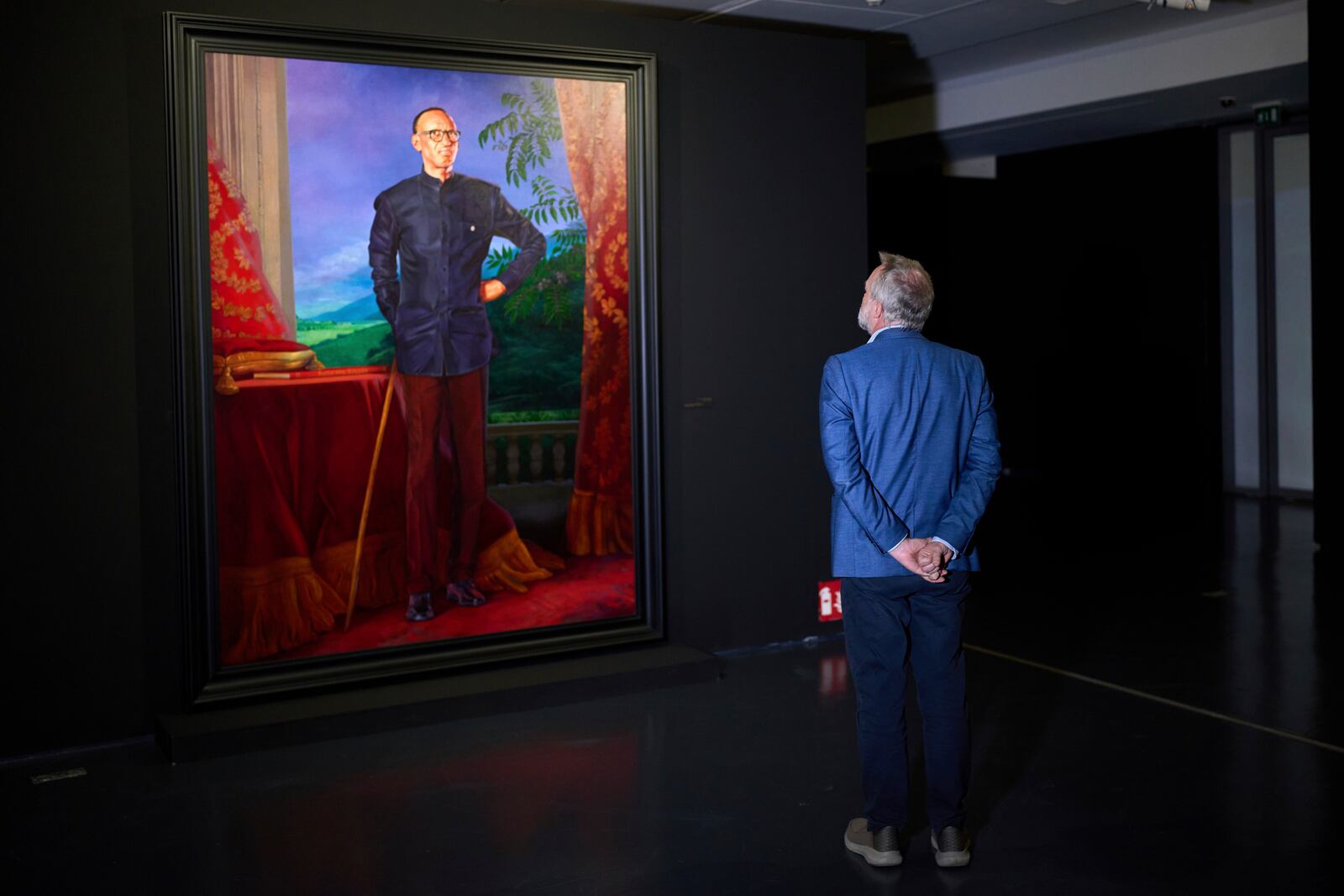 A visitors looks at a portrait of Rwanda's President Paul Kagame during the opening of American painter Kehinde Wiley's exhibition Maze of Power in Mohammed VI Museum of Modern and Contemporary Art, in Rabat, Tuesday, April 15, 2025. (AP Photo/Mosa'ab Elshamy)