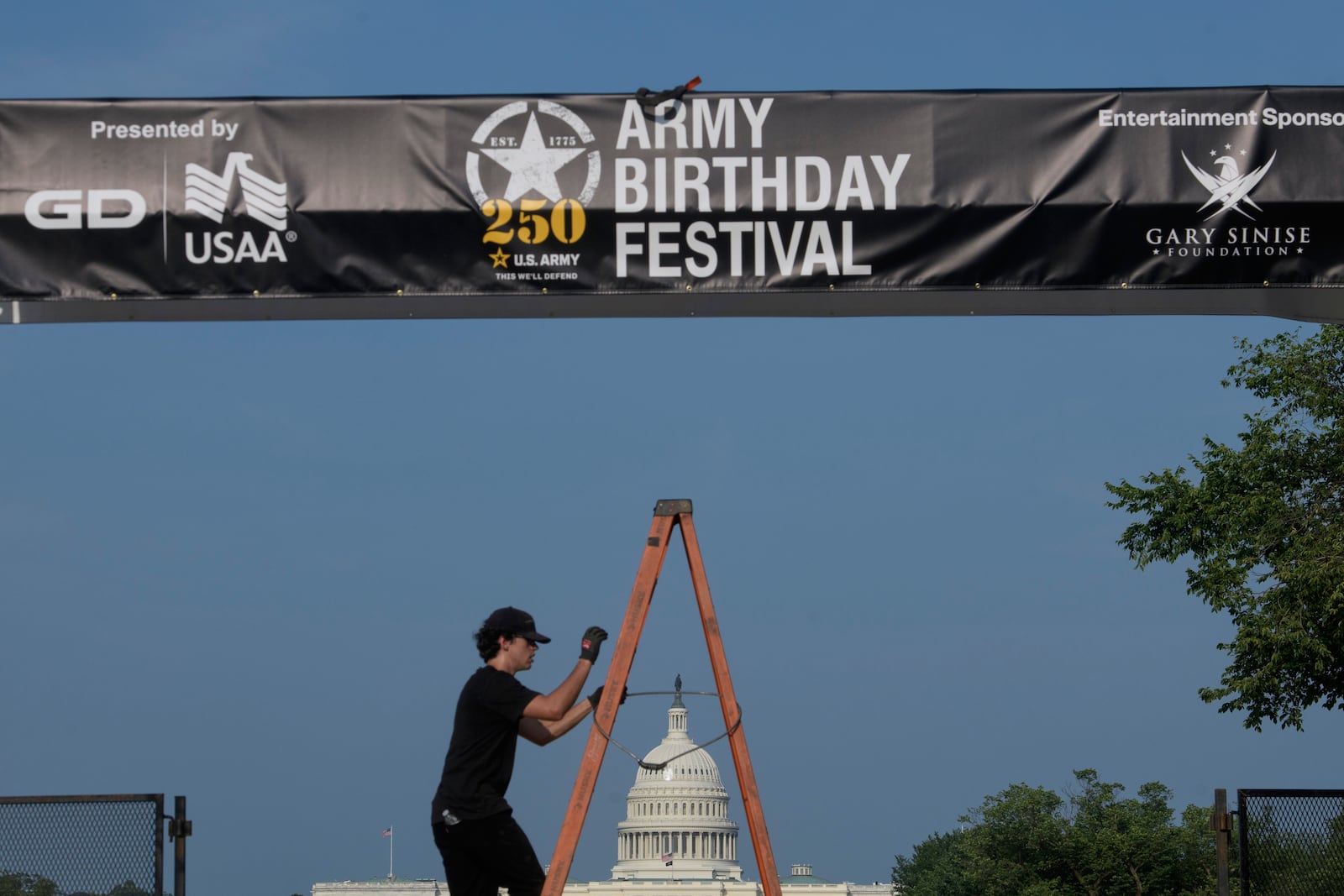 Crews work on setting up an archway on the National Mall, during preparations for an upcoming military parade commemorating the Army's 250th anniversary and coinciding with President Donald Trump's 79th birthday, Thursday, June 12, 2025, in Washington. (AP Photo/Rod Lamkey, Jr.)