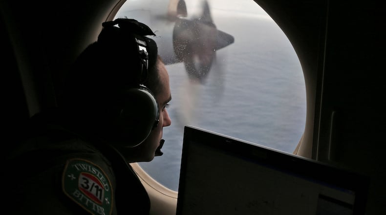 FILE - Flight officer Rayan Gharazeddine scans the water in the southern Indian Ocean off Australia from a Royal Australian Air Force AP-3C Orion during a search for the missing Malaysia Airlines Flight MH370 on March 22, 2014. (AP Photo/Rob Griffith, File)wld