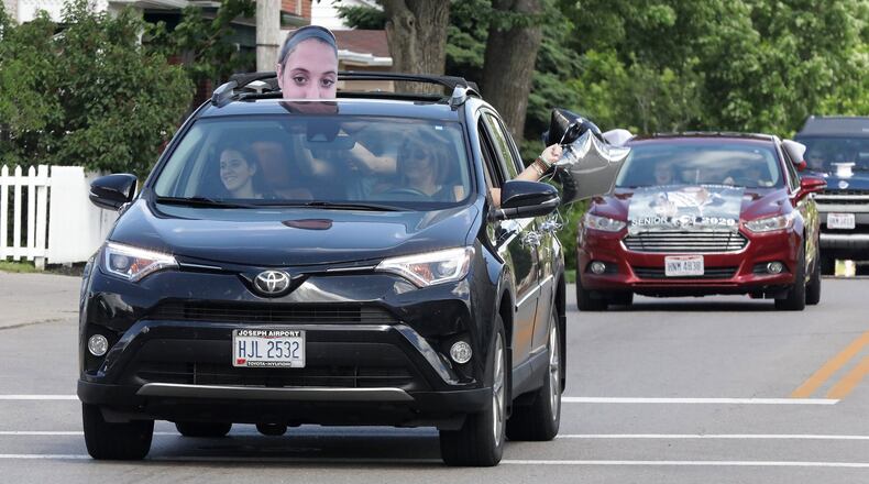 Graduating seniors at Graham High School participate in a graduation parade through St. Paris Thursday. The seniors were led by a Champaign County Sheriff’s cruiser as they traveled from St. Paris to Christiansburg and around to all the small towns in the school district. BILL LACKEY/STAFF
