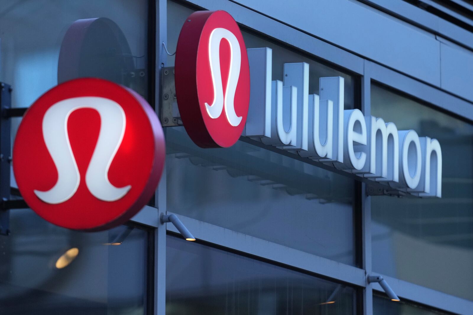 FILE - Lululemon signs are displayed outside a retail location in the Seaport District, Dec. 13, 2024, in Boston. (AP Photo/Charles Krupa, File)