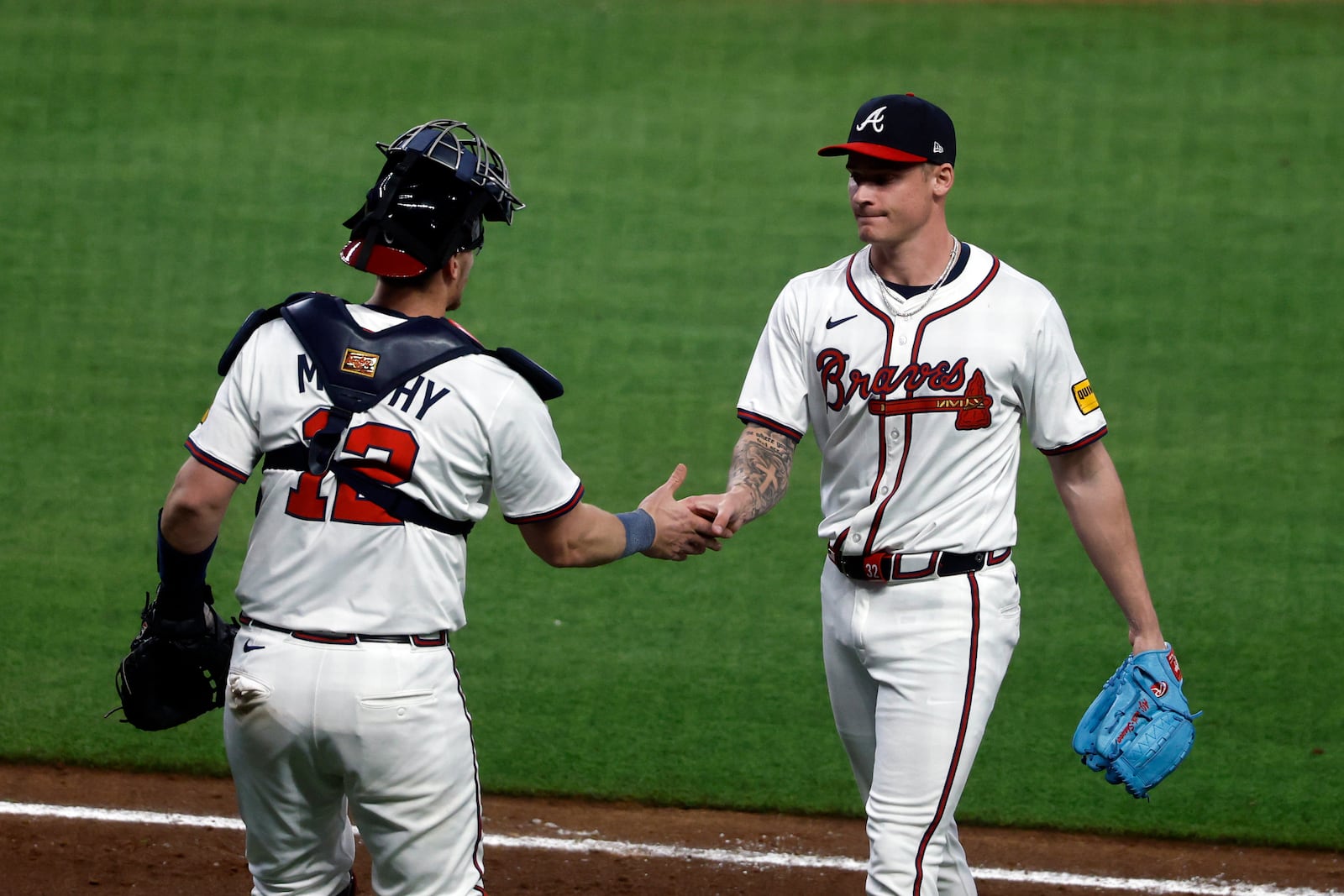 Atlanta Braves catcher Sean Murphy (12) congratulates pitcher AJ Smith-Shawver, right, during the eighth inning of a baseball game against the Cincinnati Reds, Monday, May 5, 2025, in Atlanta. (AP Photo/Butch Dill)