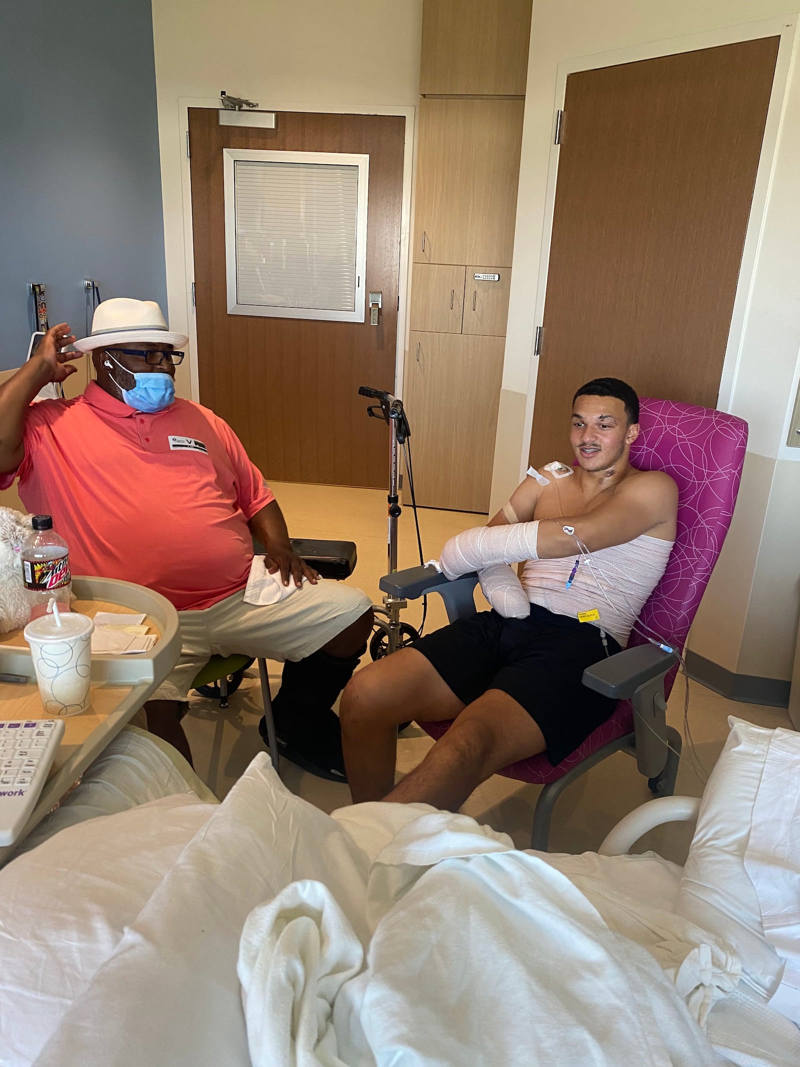 Issiah Evans (Right) in the hospital with his coach and mentor Kerry Ivy (Left) who encouraged him to recover fully before rushing to return to football. CONTRIBUTED