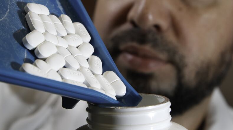 Heartland Pharmacy pharmacist Dr. Kindy Ghussin shows extra strength Vicodin tablets at the Kettering pharmacy. CHRIS STEWART / STAFF