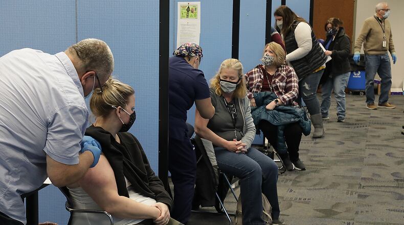 Original cutline: Champaign County teachers get the COVID vaccine Friday at the Champaign County Health District. BILL LACKEY/STAFF