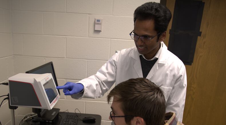 Dr. Mohan Pereira conducts research with a student in the new biophysics lab. Contributed