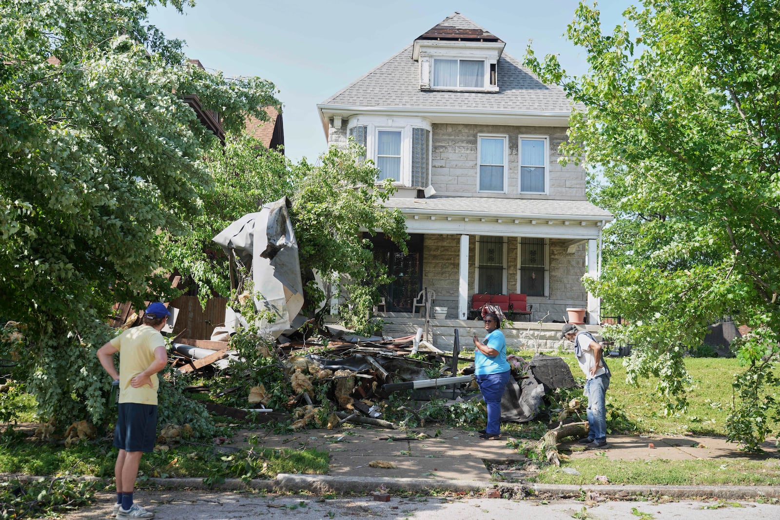 People survey damage after a severe storm moved through Friday, May 16, 2025, in St. Louis. (AP Photo/Jeff Roberson)