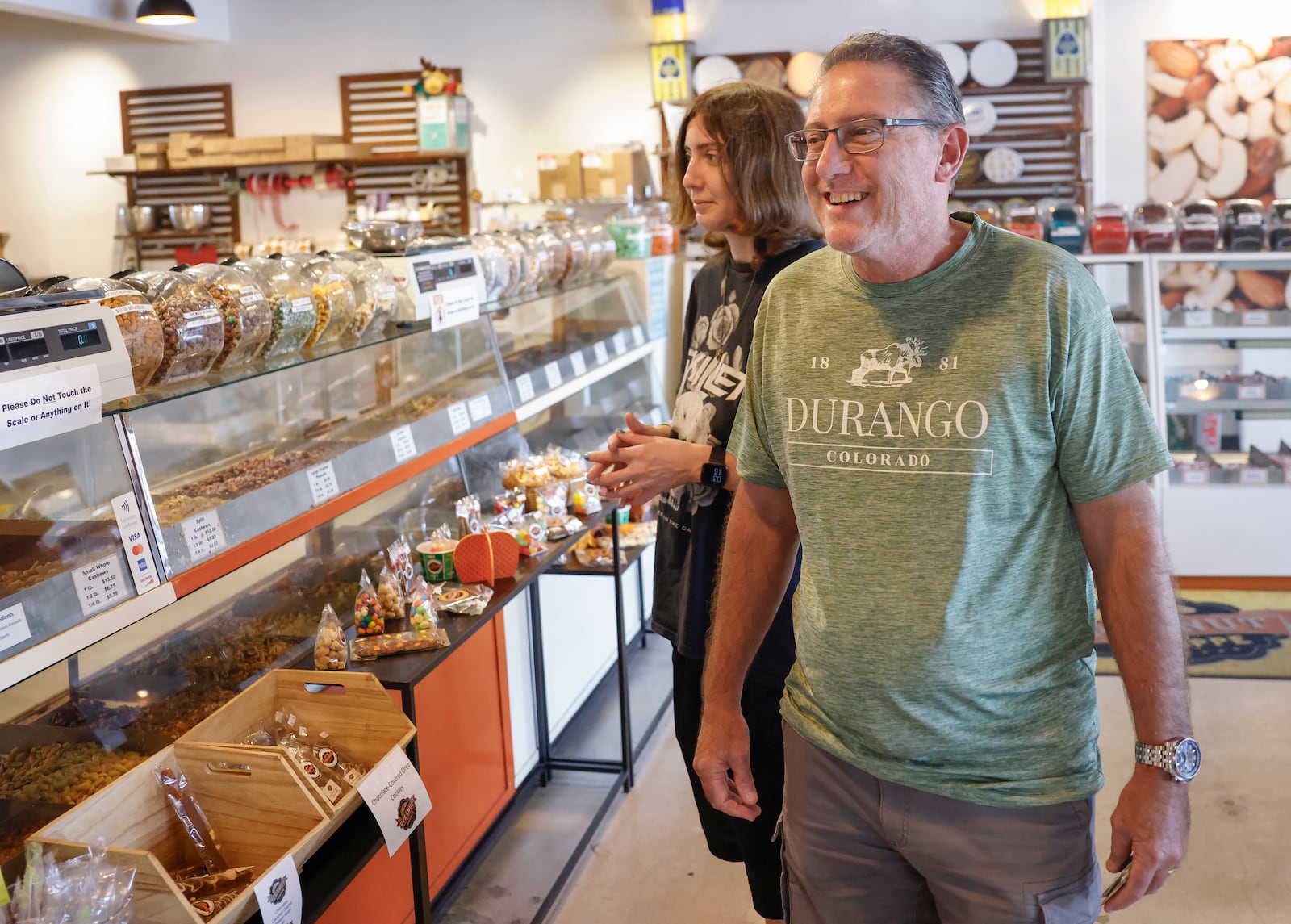 John Webster, right, and his daughter, Christal Webster, look at peanuts around them at the Peanut Shoppe on Wednesday, September 3, 2025, in Springfield. JOSEPH COOKE/STAFF