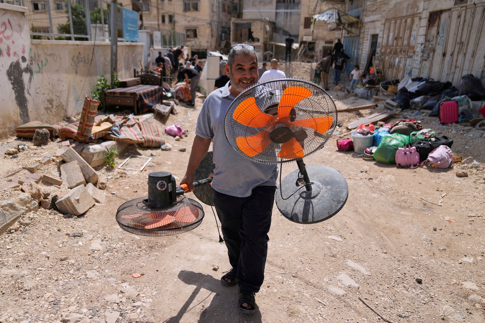 Residents of the now evacuated refugee camp of Tulkarem return to collect belongings before the destruction of their homes as Israeli forces prepare to carry out the demolition of 116 homes across the two refugee camps of the Israeli occupied West Bank city of Tulkarem, Friday, May 2, 2025. (AP Photo/Nasser Nasser)