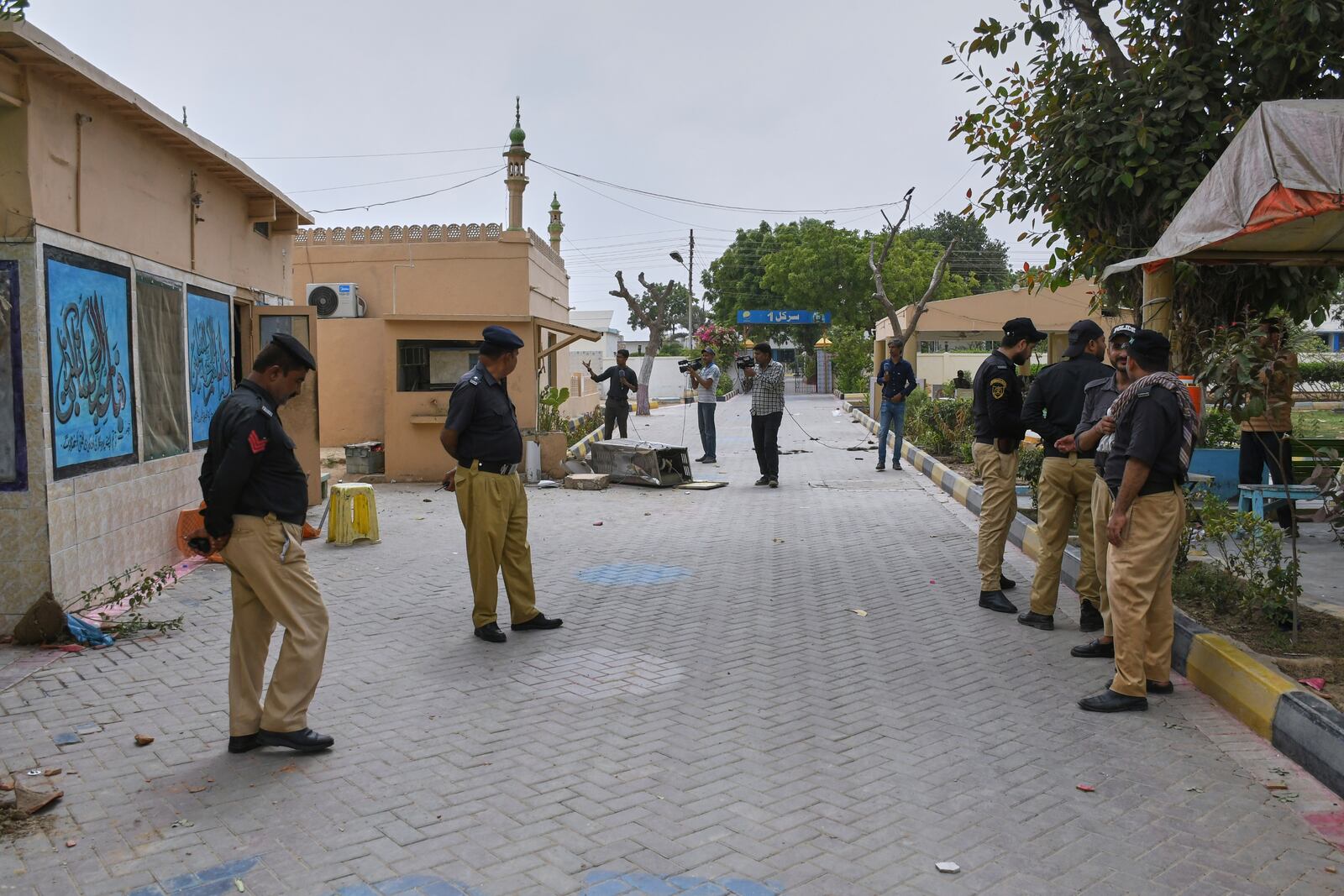 Police officer stand guard as members of media film inside the premises of the district Malir prison from where more than 100 inmates escaped overnight, in Karachi, Pakistan, Tuesday, June 3, 2025. (AP Photo/Ali Raza)