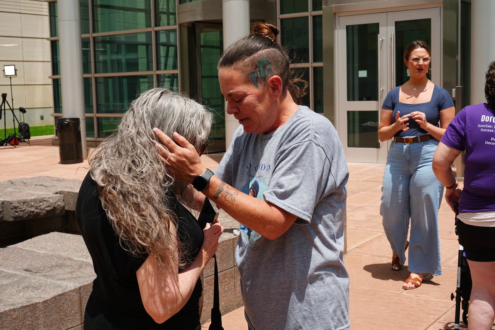 Crystina Page, right, hugs Beth Mosley after a Colorado funeral home owner who stashed nearly 190 decomposing bodies was sentenced to 20 years prison on federal fraud charges, Friday, June 27, 2025, in Denver. (AP Photo/David Zalubowski)