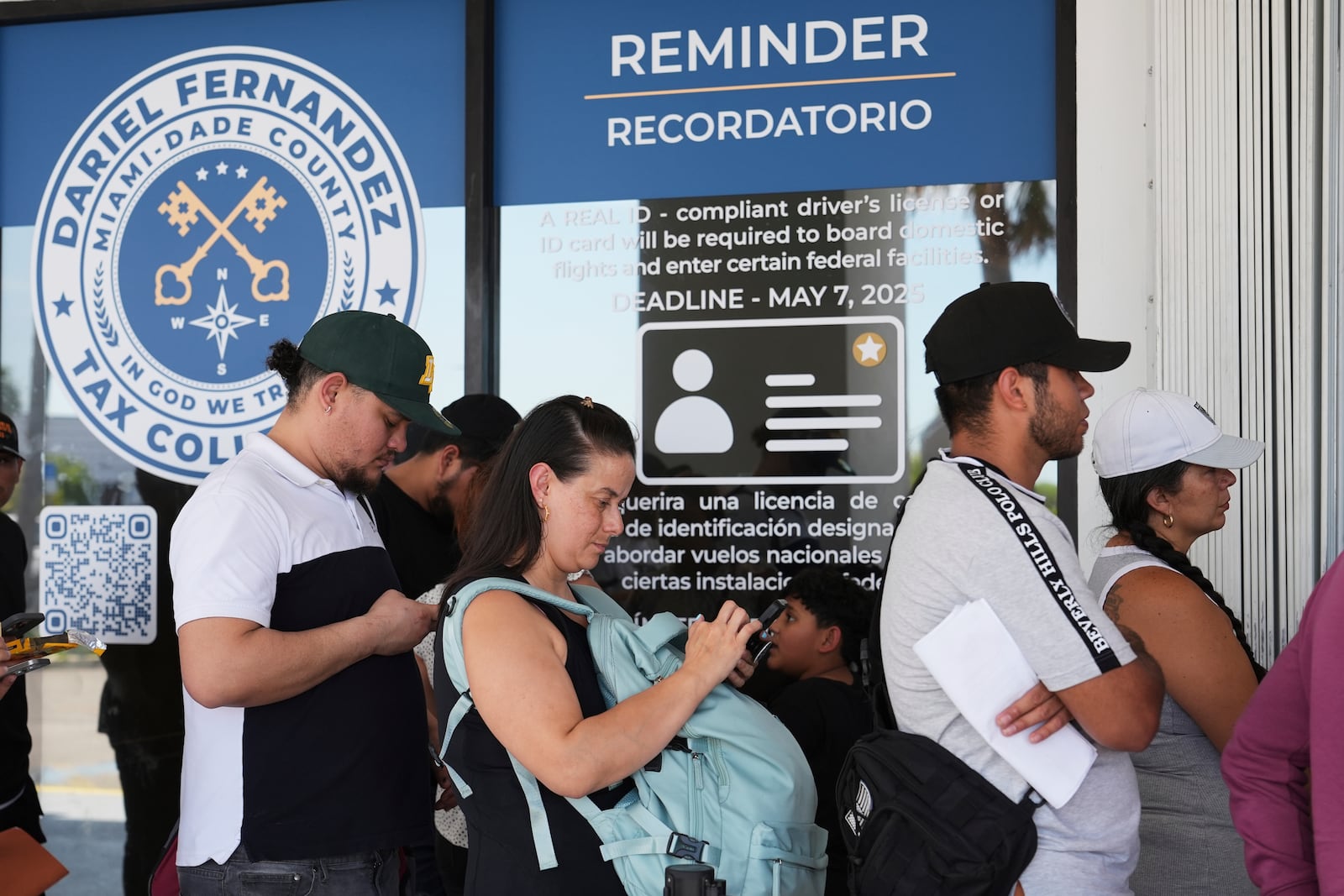 People stand in line outside of a Miami-Dade County Office of the Tax Collector Tuesday, May 6, 2025, in Miami. (AP Photo/Lynne Sladky)