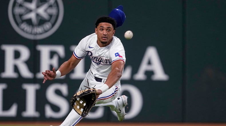 Texas Rangers left fielder Bubba Thompson lunges for the ball hit for a double by Kansas City Royals' Vinnie Pasquantino during the fourth inning of a baseball game, Tuesday, April 11, 2023, in Arlington, Texas. (AP Photo/Tony Gutierrez)