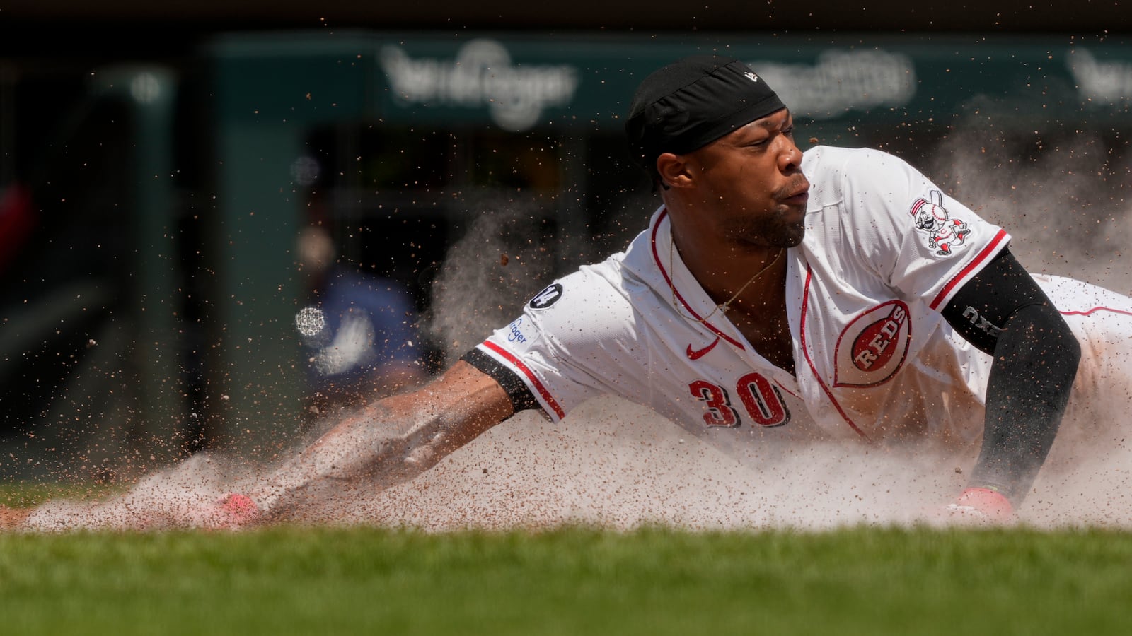 Cincinnati Reds' Will Benson slides safely into home to score on a single hit by Matt McLain during the sixth inning of a baseball game against the Atlanta Braves, Friday, Aug. 1, 2025, in Cincinnati. (AP Photo/Carolyn Kaster)