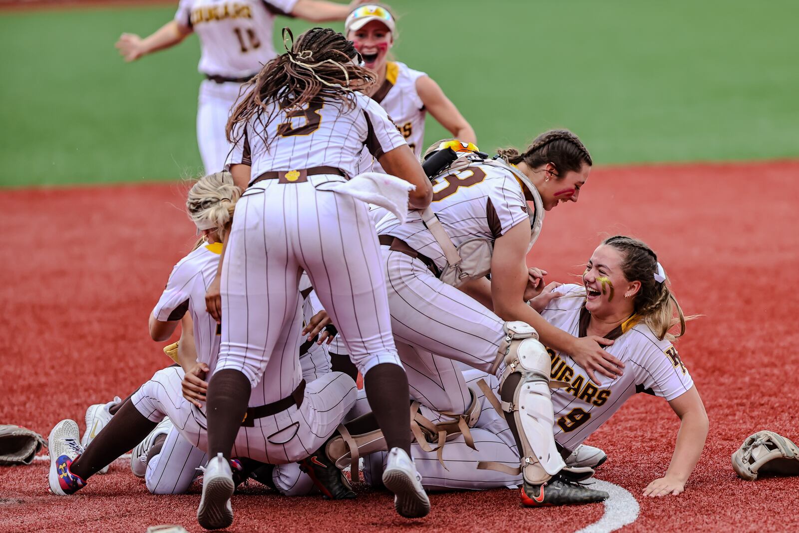 The Kenton Ridge High School team celebrates after getting the last out to win the Division IV state championship game on Thursday, June 5 at Akron's Firestone Stadium. The Cougars beat Hillsboro 9-0. MICHAEL COOPER / STAFF