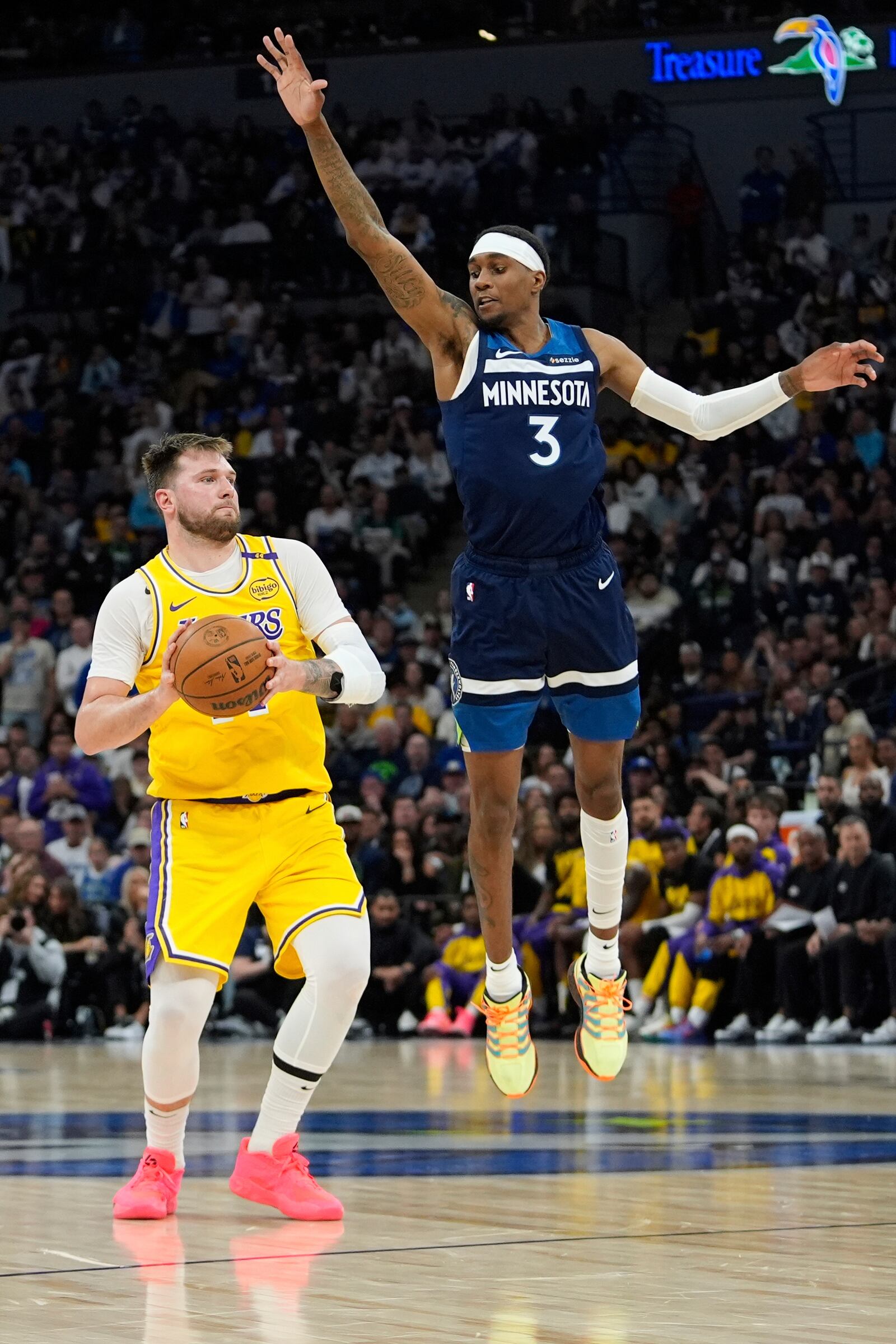 Los Angeles Lakers guard Luka Doncic (77) looks to pass as Minnesota Timberwolves forward Jaden McDaniels (3) defends during the second half of Game 3 of an NBA basketball first-round playoff series, Friday, April 25, 2025, in Minneapolis. (AP Photo/Abbie Parr)