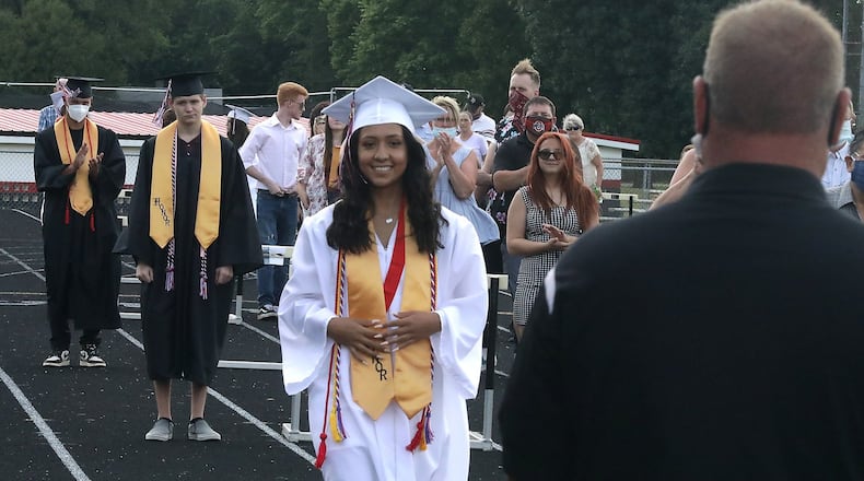 Greenon High School held a socially distanced graduation ceremony last year. Students and their families lined up 10 feet apart around the school’s track and waited for their names to be called. Social distancing will be in effect this year, but students will be seated on the football field. BILL LACKEY/STAFF