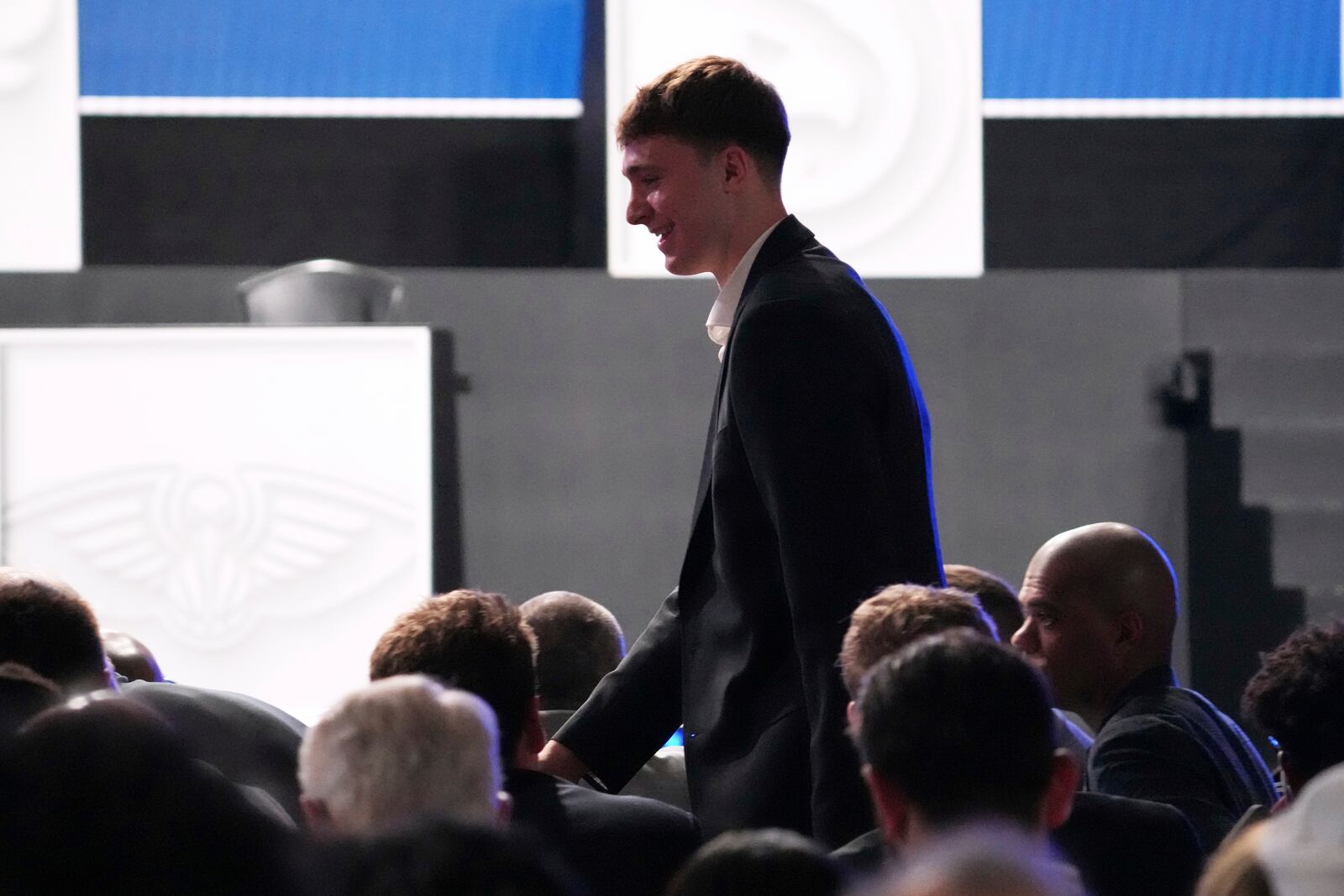 Duke's Cooper Flagg walks back to his seat after he was interviewed by ESPN after the Dalas Mavericks won the first pick in the NBA basketball draft lottery in Chicago, Monday, May 12, 2025. (AP Photo/Nam Y. Huh)