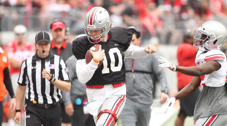 Ohio State’s Joe Burrow, left, is pushed out of bounds during the spring game on Saturday, April 14, 2018, at Ohio Stadium in Columbus. David Jablonski/Staff