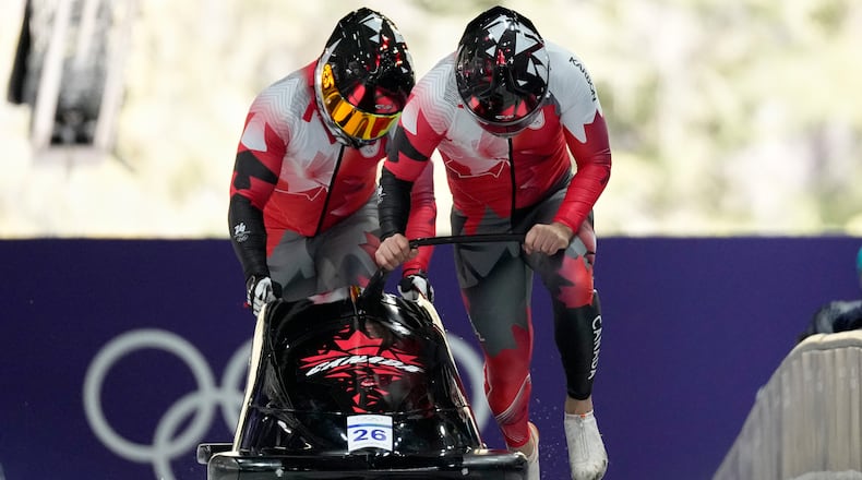 Canada's Taylor Austin, right, and Shaquille Murray-Lawrence start for a two man bobsled run at the 2026 Winter Olympics, in Cortina d'Ampezzo, Italy, Monday, Feb. 16, 2026. (AP Photo/Alessandra Tarantino)