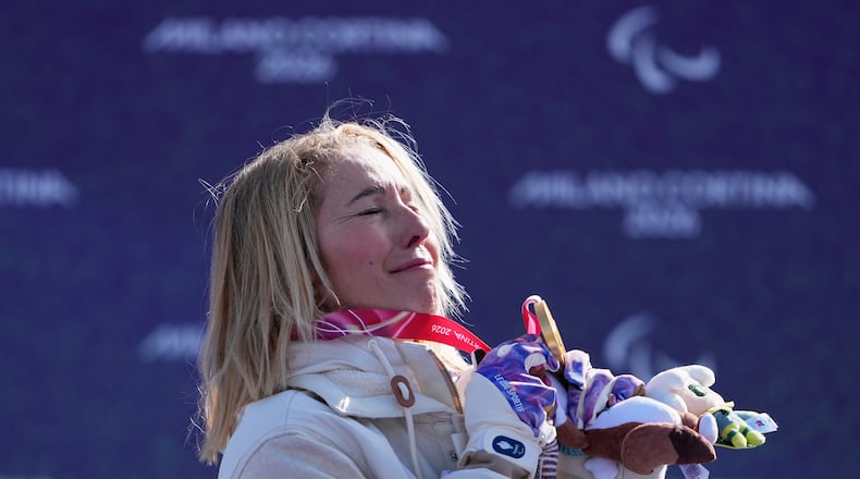 Cecile Hernandez, of France, stands on the podium after winning the gold medal in the women's snowboard cross SB-LL2 at the 2026 Winter Paralympics, in Cortina d'Ampezzo, Italy, Sunday, March 8, 2026. (AP Photo/Evgeniy Maloletka