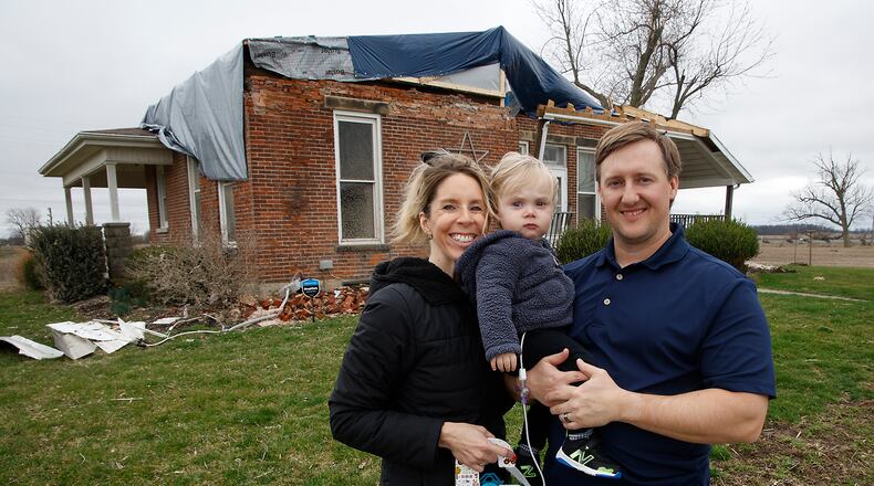 Jennifer and Seth Cosby are shown with their son John in front of their damaged house on South Buena Vista Road in Clark County Saturday, March 11, 2024. BILL LACKEY/STAFF