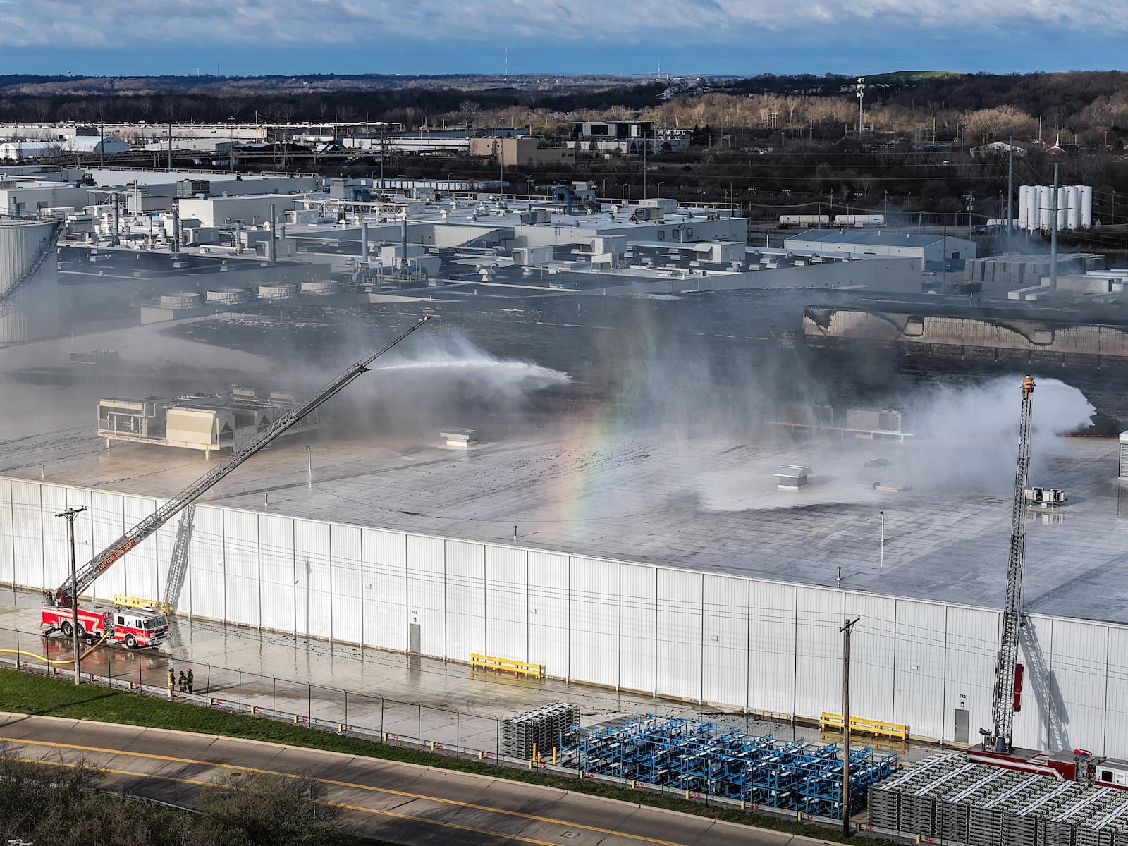 Morning crews work to extinguish remaining flames at the Fuyao Glass America plant in Moraine following a large fire. NICK GRAHAM / STAFF