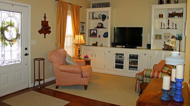 An area of built-in cabinetry and shelving lines the far wall of the living room.