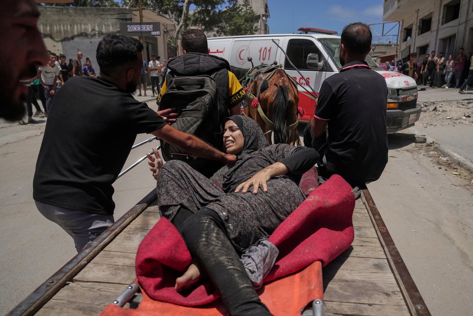 A woman is evacuated after an Israeli strike on tents sheltering displaced Palestinians in Gaza City on Tuesday, July 8, 2025. (AP Photo/Jehad Alshrafi)
