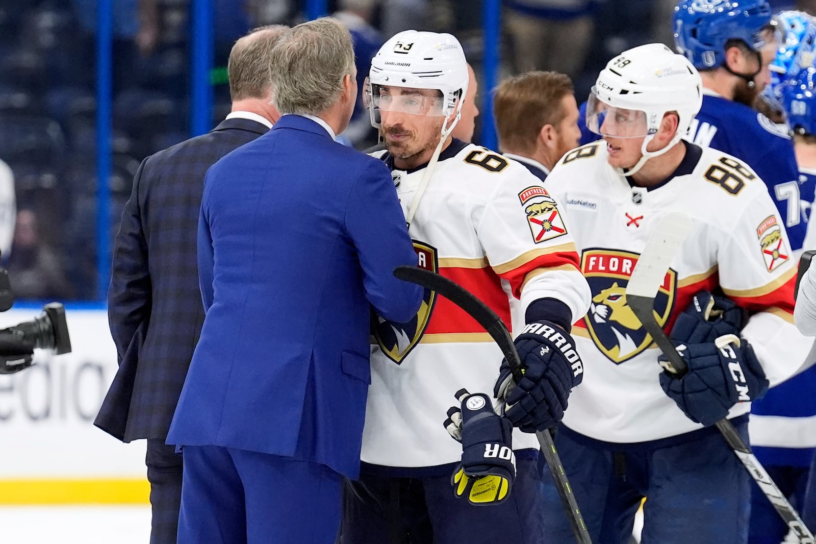 Florida Panthers center Brad Marchand (63) hugs against the Tampa Bay Lightning head coach Jon Cooper after Game 5 of an NHL hockey Stanley Cup first-round playoff series, Wednesday, April 30, 2025, in Tampa, Fla. (AP Photo/Chris O'Meara)