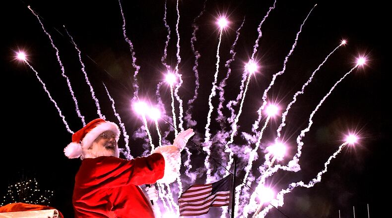 Santa turns and waves to the crowd as fireworks launch behind him on the Springfield City Hall Plaza during the Holiday in the City festival in 2016. Bill Lackey/Staff