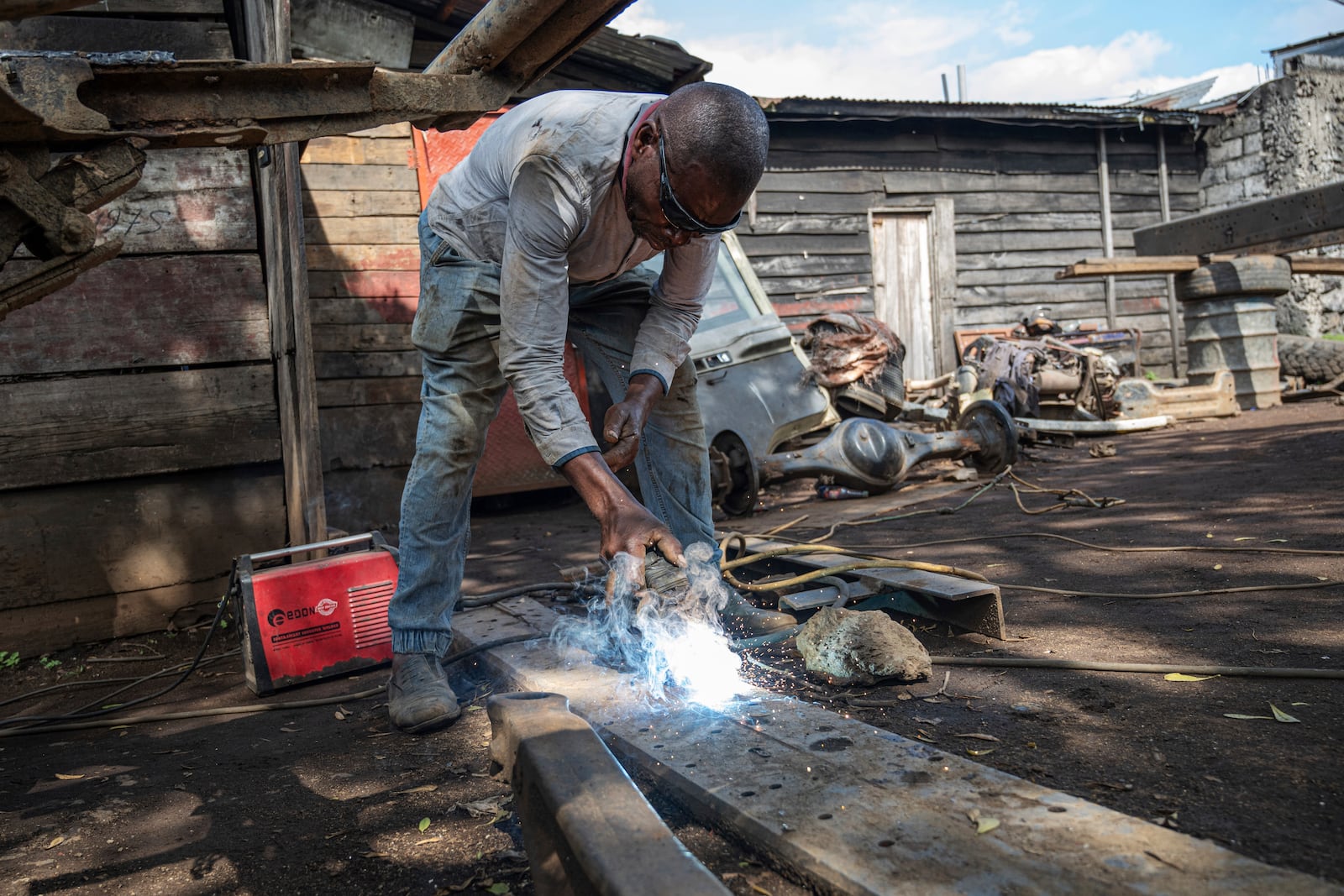 Mahamudu Bitego, a welder, whose business is powered in part by solar energy, works in Goma, Congo, May 23, 2025. (AP Photo/Moses Sawasawa)
