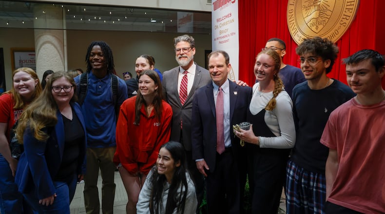 Dr. Christian M. M. Brady, center left, and Michael Frandsen, right center, take a photo with students during an event where Brady was announced as the 16th president on Friday, May 9, 2025, at Wittenberg University. Frandsen was the 15th president. JOSEPH COOKE/STAFF