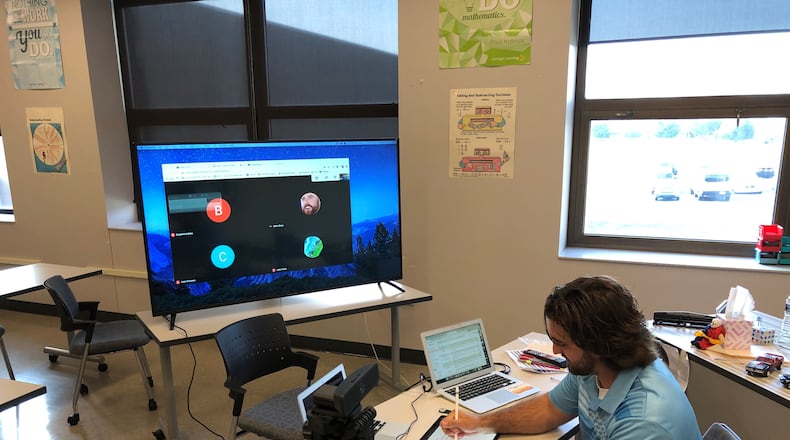 Global Impact STEM Academy teacher Mr. Sexton going over Algebra 2 equations while screen casting his iPad. The academy is planning to start bringing students back to the building in October.