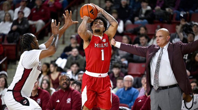 Miami Ohio guard Trey Perry shoots as UMass guard K'Jei Parker, left, defends and UMass head coach Frank Martin looks on, in the first half of an NCAA college basketball game, Tuesday, Feb. 17, 2026, in Amherst, Mass. (AP Photo/Jessica Hill)