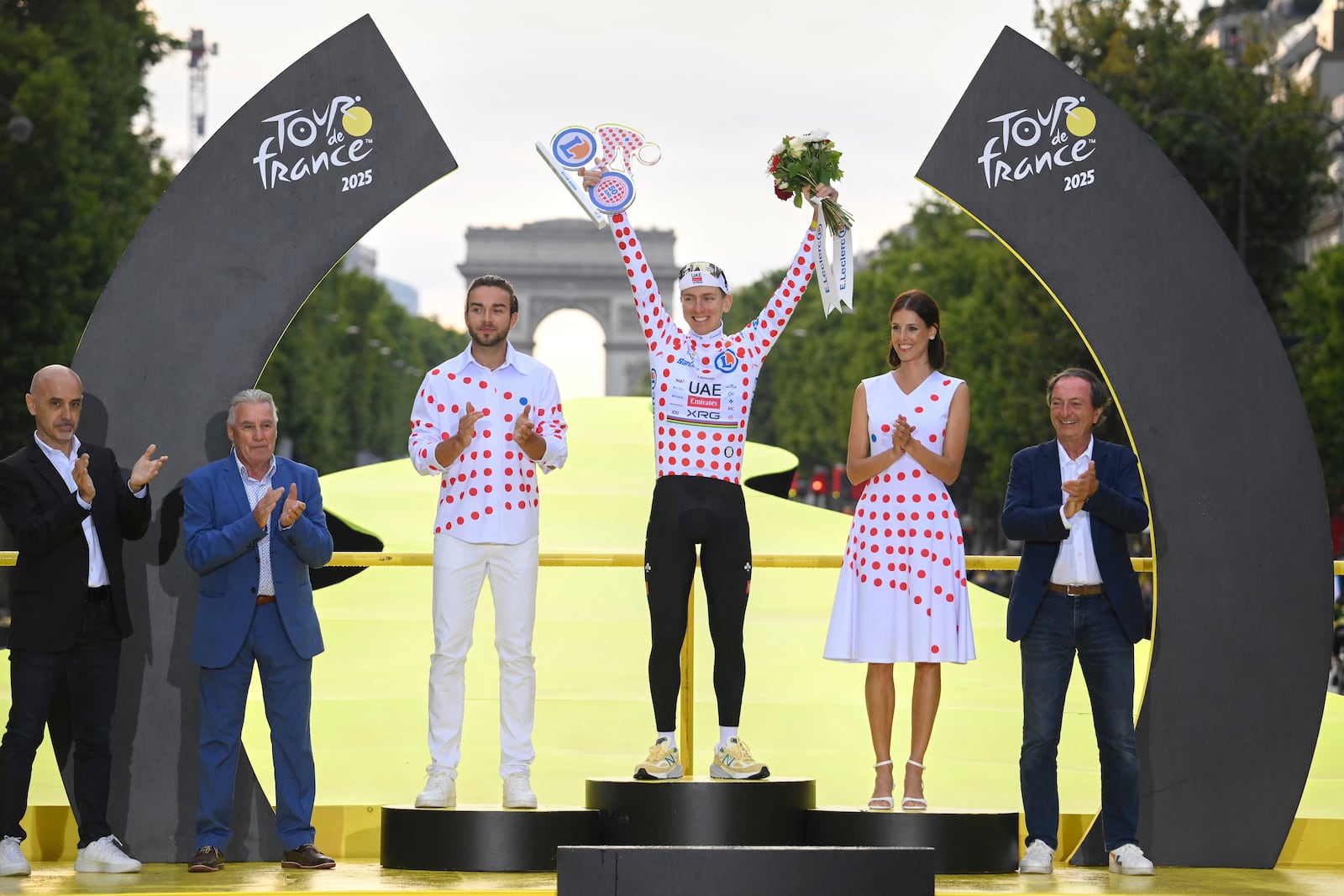 Slovenia's Tadej Pogacar, holds the award for the best climber as he celebrates during the presentation ceremony for the Tour de France on the Champs-Elysees in Paris, France, Sunday, July 27, 2025. (Bernard Papon, Pool Photo via AP)