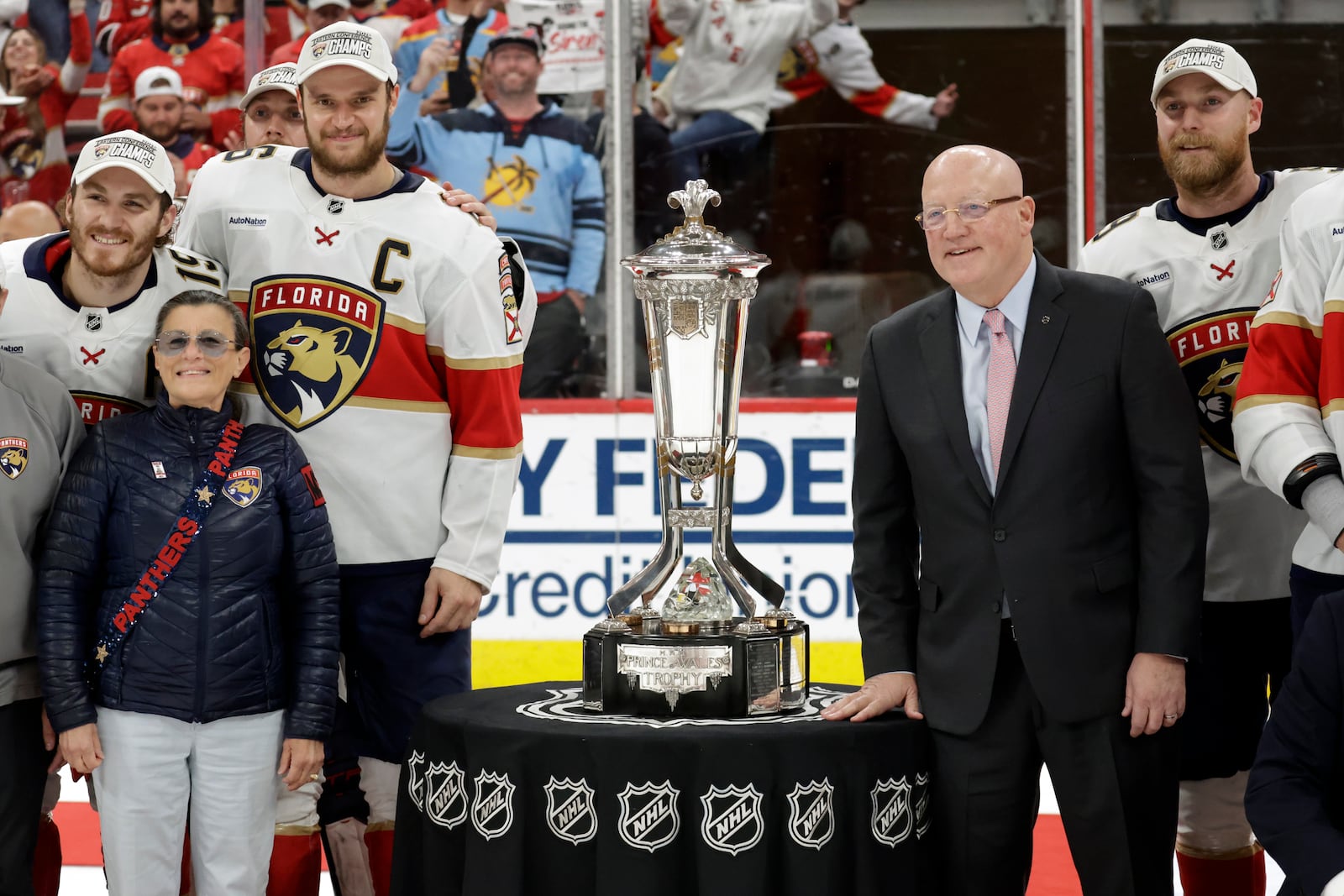 Florida Panthers center Aleksander Barkov (C) and NHL Deputy Commissioner Bill Daly, right, pose with the Prince of Wales trophy at the end of Game 5 of the NHL hockey Stanley Cup Eastern Conference finals Wednesday, May 28, 2025, in Raleigh, N.C. They advance to the Stanley Cup finals. (AP Photo/Chris Seward)