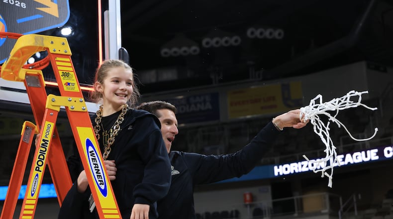 Wright State University coach Clint Sargent and his daughter, Gracie, cut down the net after their 66-63 victory over Detroit Mercy in the Horizon League tournament final on Tuesday, March 10, 2026 at Corteva Coliseum in Indianapolis. HORIZON LEAGUE / CONTRIBUTED PHOTO