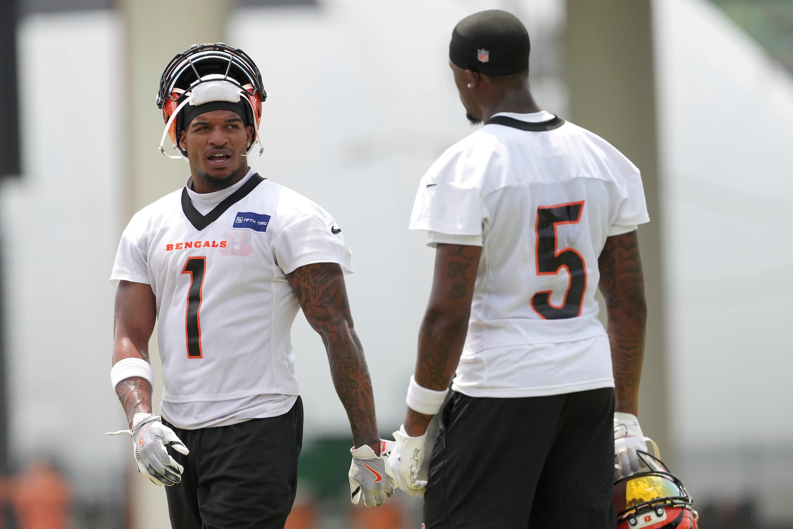 Cincinnati Bengals wide receivers Ja'Marr Chase (1), left, and Tee Higgins (5), right, talk during NFL football practice Tuesday, June 3, 2025, in Cincinnati. (AP Photo/Kareem Elgazzar)