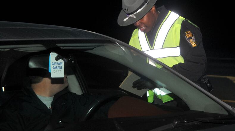 A Ohio State Highway Patrol trooper hands out an information sheet to a driver during an OVI sobriety checkpoint. David A. Moodie/Contributor