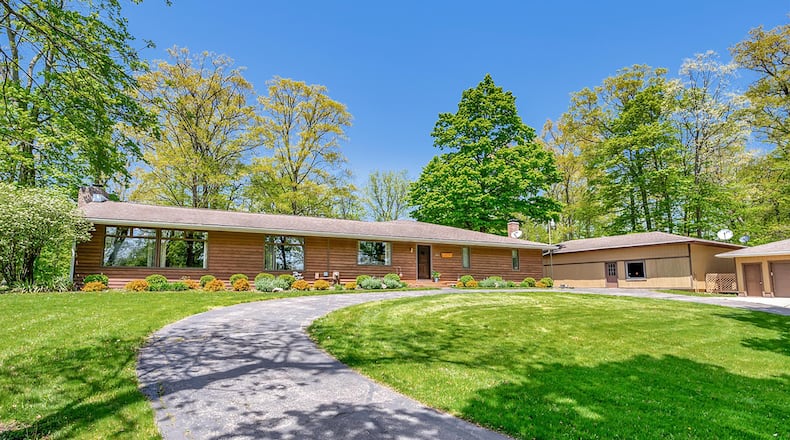 The front of the wood-sided ranch home has a circular asphalt driveway and a detached three-car garage. Contributed photos
