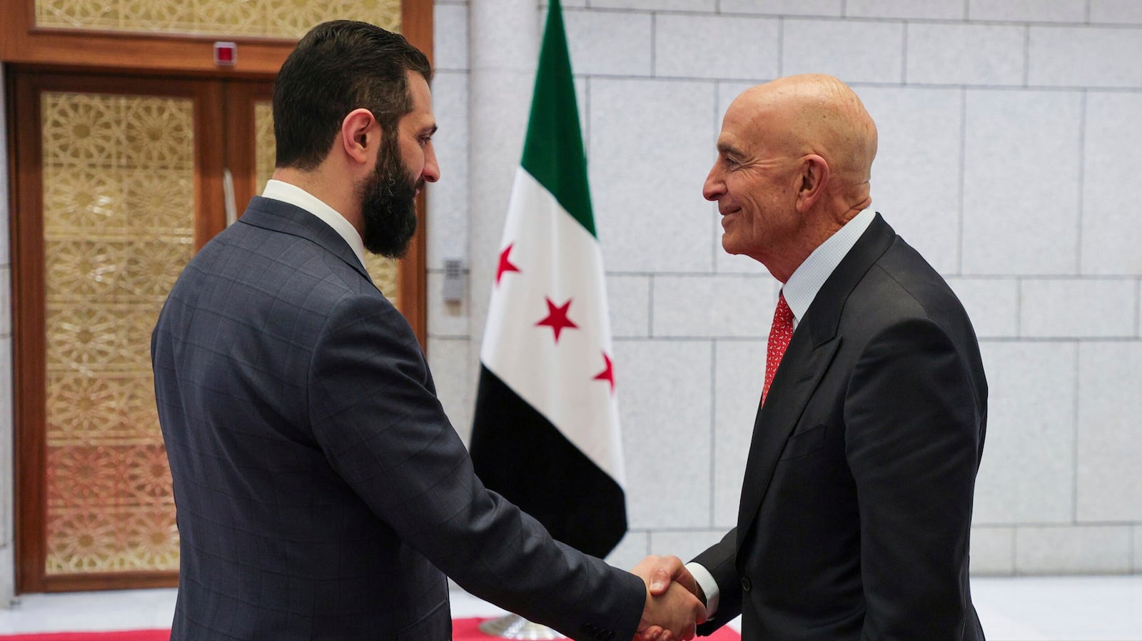 In this photo released by the Syrian official news agency SANA, Syria's interim President Ahmad al-Sharaa, left, shakes hands with U.S. Ambassador to Turkey and Special Envoy to Syria Tom Barrack, in Damascus, Syria, May 29, 2025. (SANA via AP)
