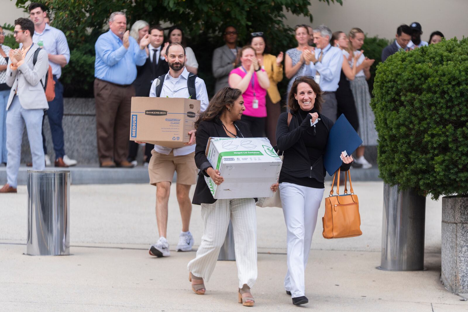 State Department employees cheer to recognize the service of their fired co-workers who are carrying boxes and their personal belongings out of the Harry S. Truman Building, the headquarters of the State Department, in Washington, Friday, July 11, 2025, as they , (AP Photo/Manuel Balce Ceneta)
