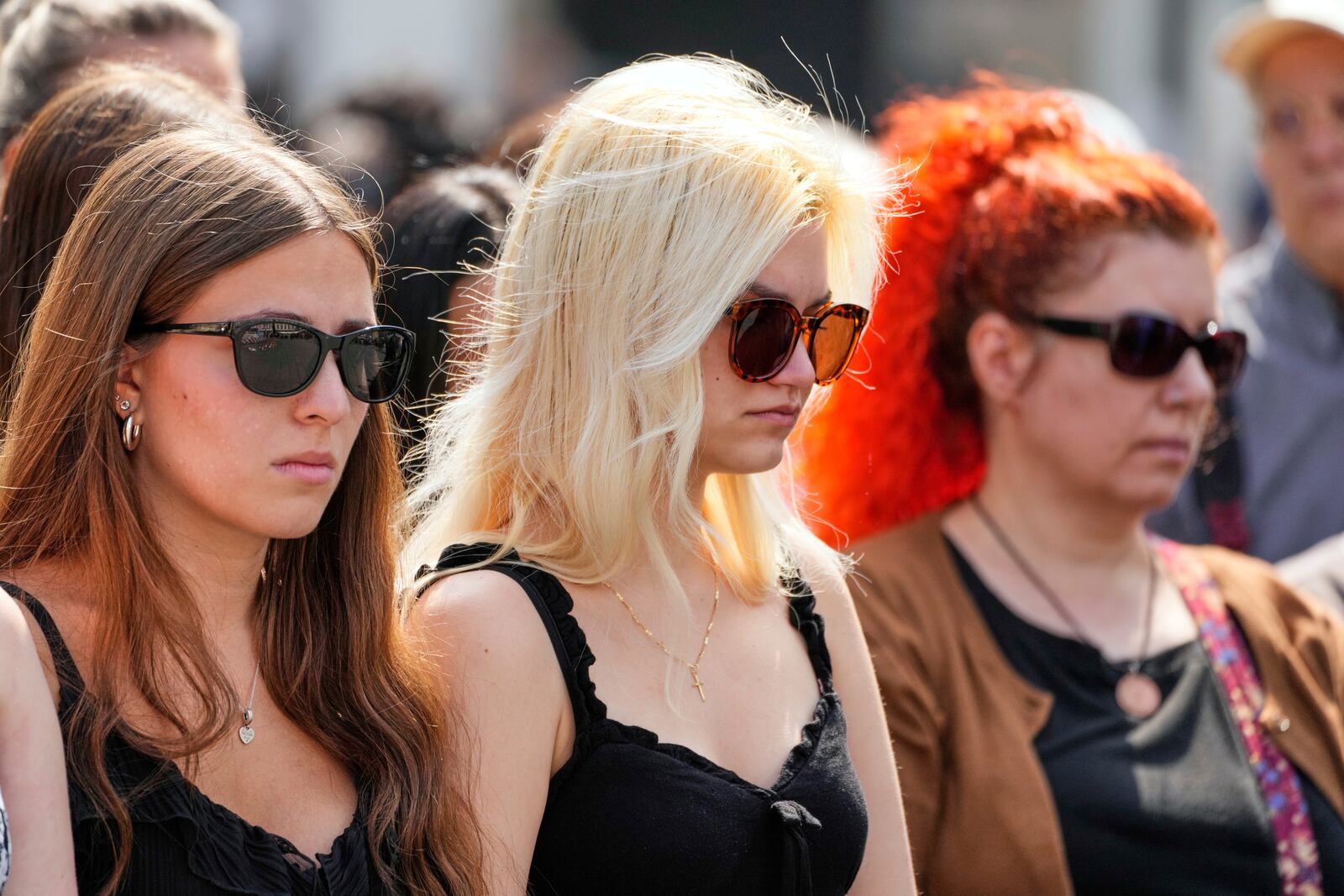 People pay a moment of silence on the main square after a former student opened fire the day before at a school fatally wounding several people and injuring many others before taking his own life, Graz, Austria, Wednesday, June 11, 2025. (AP Photo/Darko Bandic)