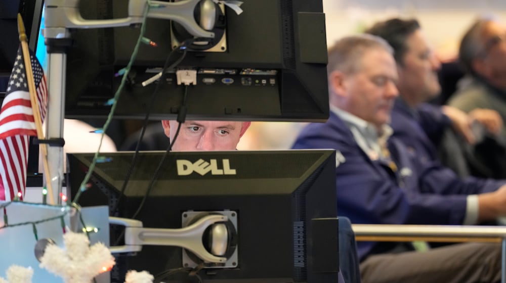Justin Flinn, left, works on the floor at the New York Stock Exchange in New York, Wednesday, Dec. 10, 2025. (AP Photo/Seth Wenig)