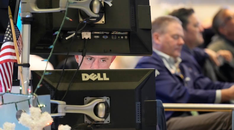Justin Flinn, left, works on the floor at the New York Stock Exchange in New York, Wednesday, Dec. 10, 2025. (AP Photo/Seth Wenig)
